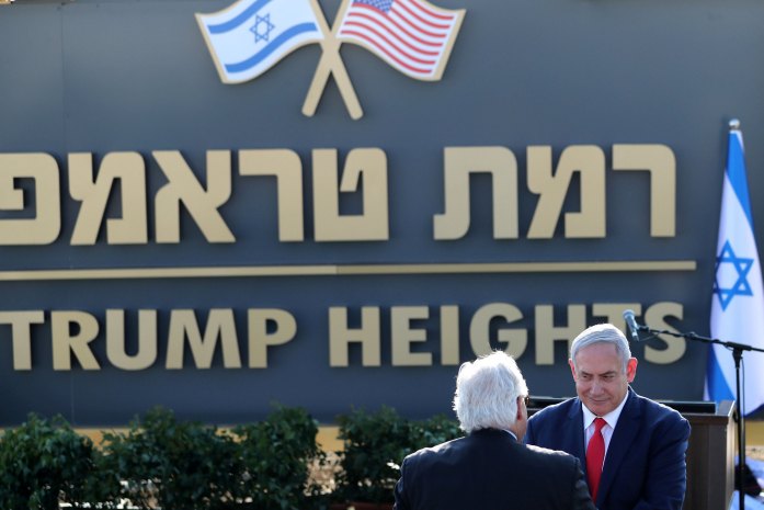 Israeli Prime Minister Benjamin Netanyahu shake hands with U.S. Ambassador to Israel David Friedman as they attend a ceremony to unveil a sign for a new community named after U.S. President Donald Trump, in the Israeli-occupied Golan Heights