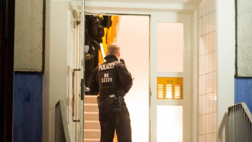 Einsatzkraefte-der-Polizei-stehen-im-Hausflur-eines-Mehrfamilienhauses-in-Marzahn-Hellersdorf