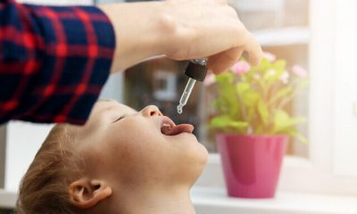 mother giving vitamin drops with dropper to her child. dietary supplements for kids