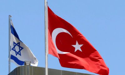 A Turkish flag flutters atop the Turkish embassy as an Israeli flag is seen nearby, in Tel Aviv, Israel