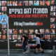 People walk past an installation with pictures of hostages taken by Palestinian Islamist group Hamas, in Jerusalem