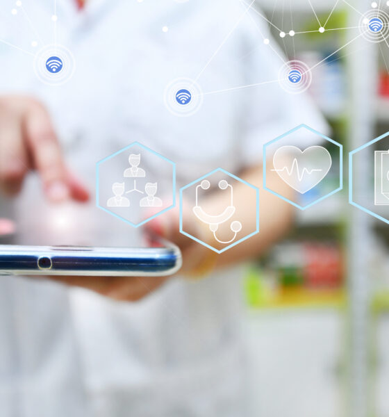 Pharmacist using mobile smart phone for search bar on display in pharmacy drugstore shelves background.