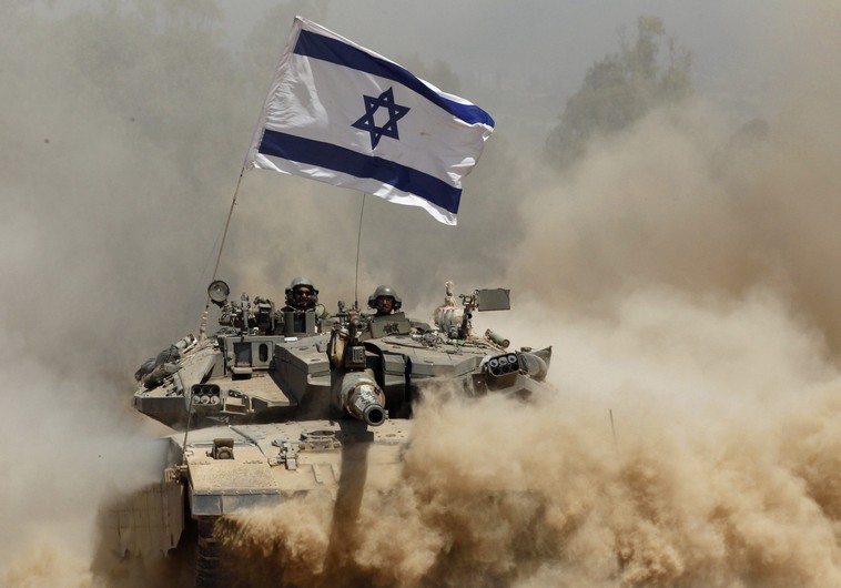 Israeli soldiers ride a tank after returning to Israel from Gaza